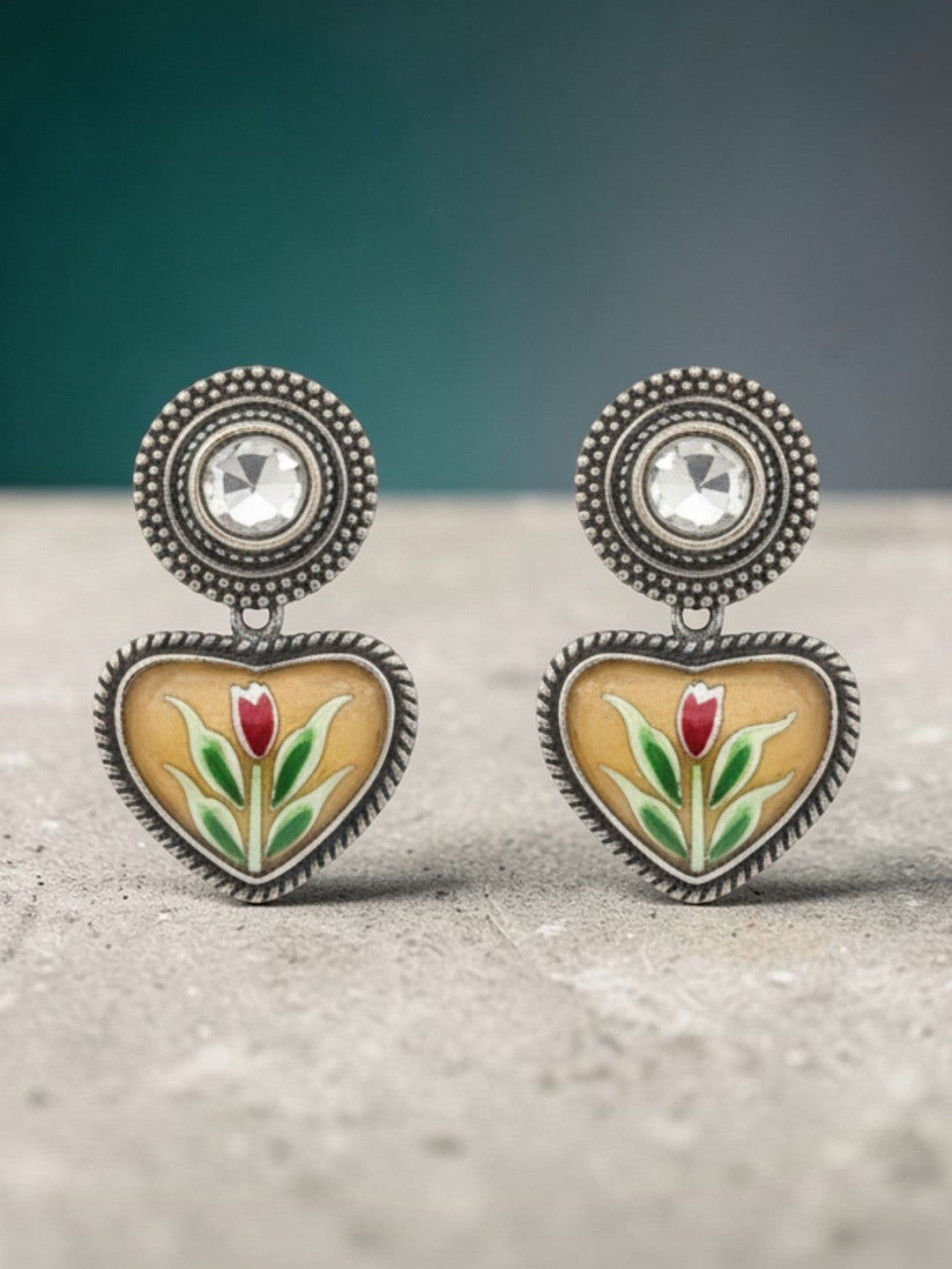Oxidised silver enamel heart stud earring worn on a woman's ear showing fit and scale