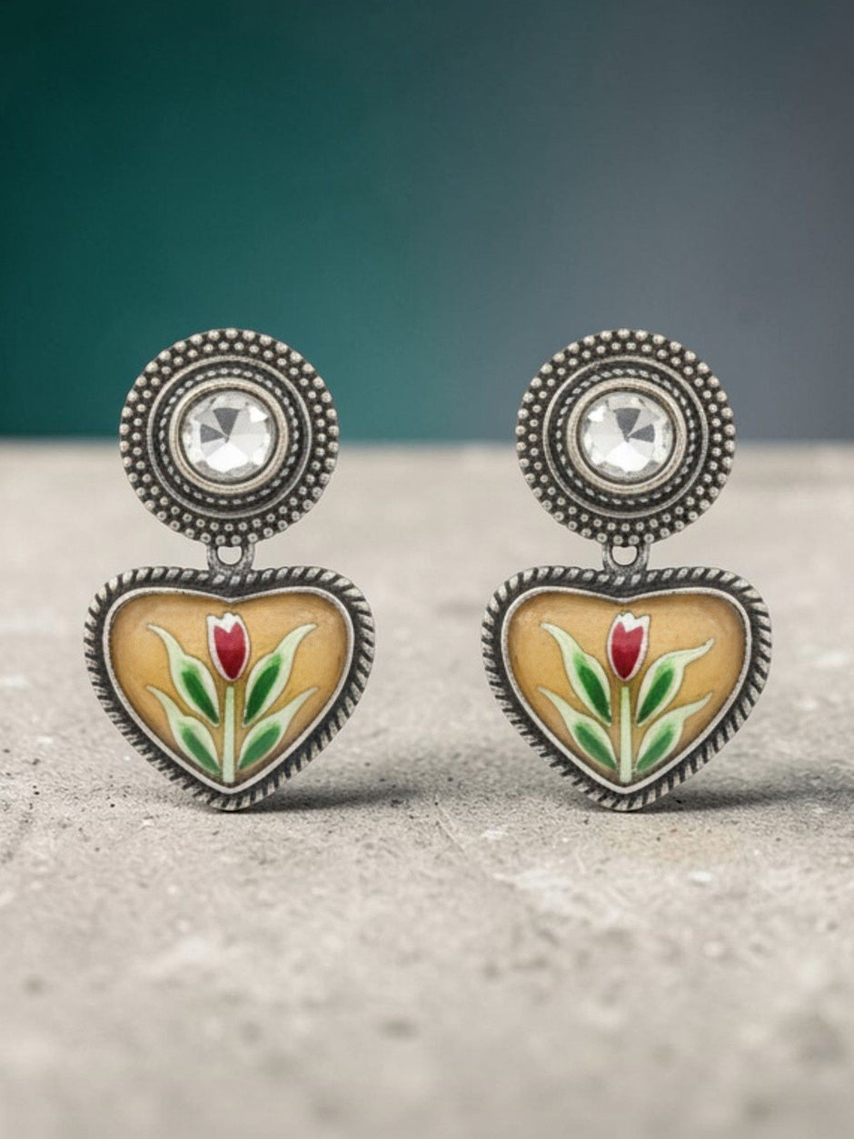 Oxidised silver enamel heart stud earring worn on a woman's ear showing fit and scale