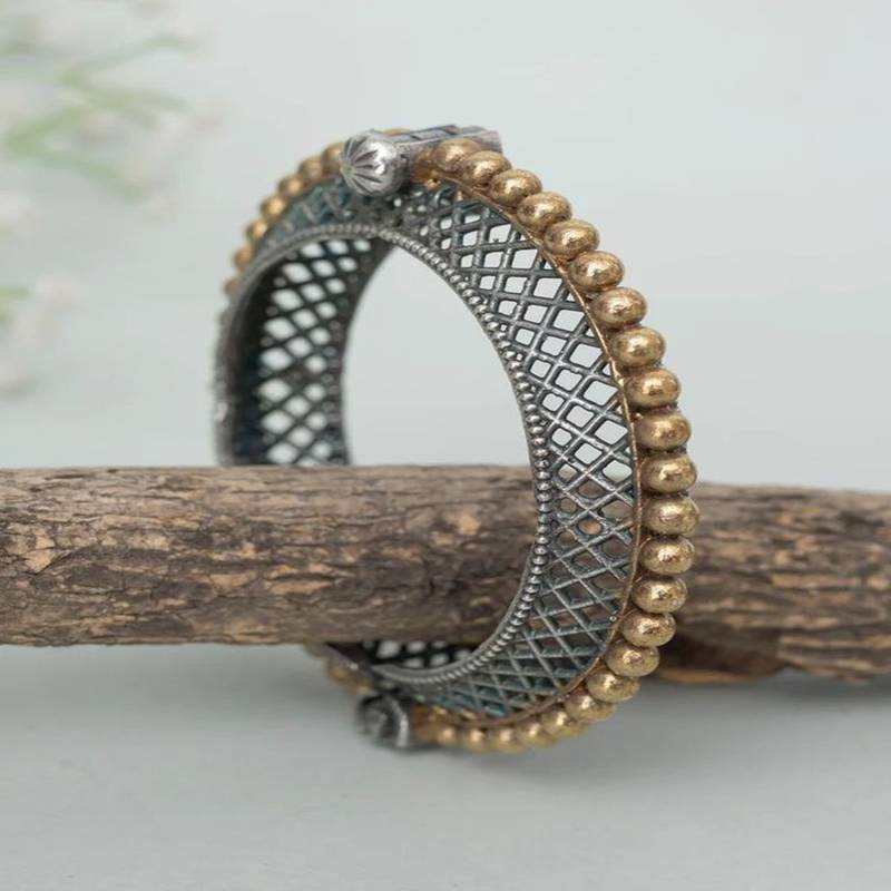 Decorative ring with intricate patterns on a wooden stick