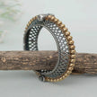 Decorative ring with intricate patterns on a wooden stick